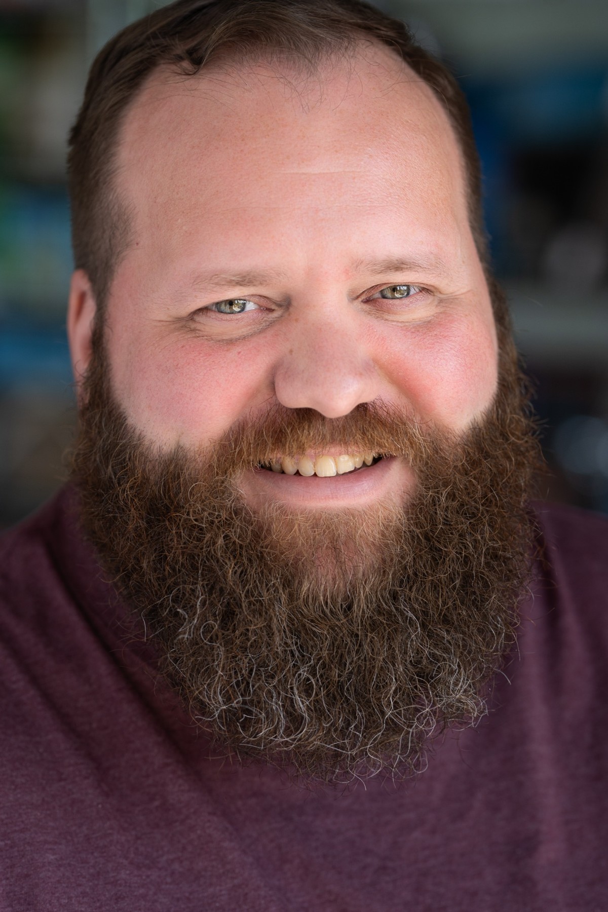 Stefan Nornholm smiling in a burgundy shirt